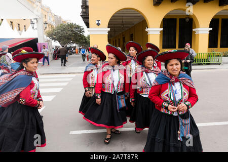 LIMA, PERU- circa OKTOBER 2019: Peruanische Damen in traditioneller ländlicher Kleidung, die über den Hauptplatz von Lima laufen Stockfoto