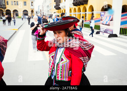 LIMA, PERU- circa OKTOBER 2019: Peruanische Damen in traditioneller ländlicher Kleidung, die über den Hauptplatz von Lima laufen Stockfoto