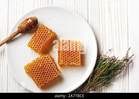 Waben auf Platte auf weißem Holz- Hintergrund. Stockfoto