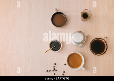 Tassen Kaffee mit Kaffeebohnen und vietnamesische Phin Filter auf Holz- Hintergrund Stockfoto