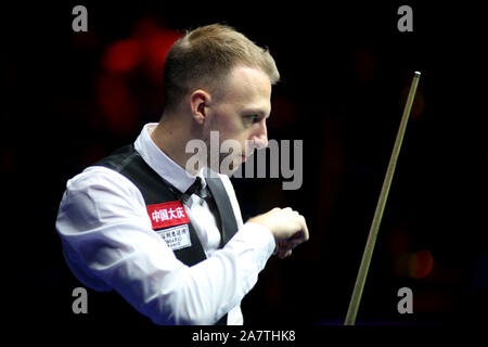 Judd Trump von England hält einen Schuß zu Tom Ford von England in ihren Viertelfinalegleichen während der 2019 World Snooker internationale Meisterschaft in Stockfoto