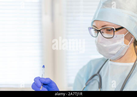 Frau Doktor in Maske mit Stethoskop Portrait Nahaufnahme Medizin Gesundheitshintergrund. Stockfoto