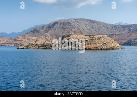 Fernschreiber Insel weg von Khasab, Musandam, Oman in den Fjorden in der Nähe der Straße von Hormuz. Der britische Telegraph Linien noch vorhanden. Blue Sky sonnigen Tag. Dhow. Stockfoto