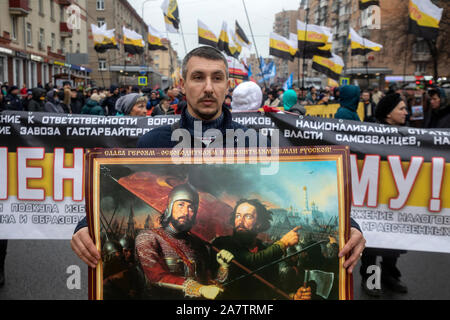 Moskau, Russland. November, 2019 ein Mann hält eine Reproduktion der Gemälde des Künstlers Michail von Scotti bin inin und Pozharsky" während einer russischen März entlang Marschall Biryuzov Straße in der Nähe der U-Bahn-Station Oktyabrskoye Pol in Moskau, Russland Stockfoto