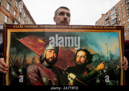 Moskau, Russland. November, 2019 ein Mann hält eine Reproduktion der Gemälde des Künstlers Michail von Scotti bin inin und Pozharsky" während einer russischen März entlang Marschall Biryuzov Straße in der Nähe der U-Bahn-Station Oktyabrskoye Pol in Moskau, Russland Stockfoto