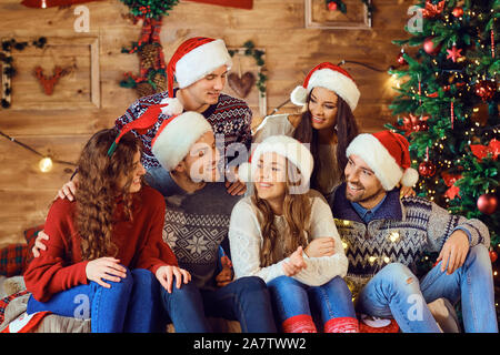 Gruppe von Lachen Freunde in Santa Hüte Stockfoto