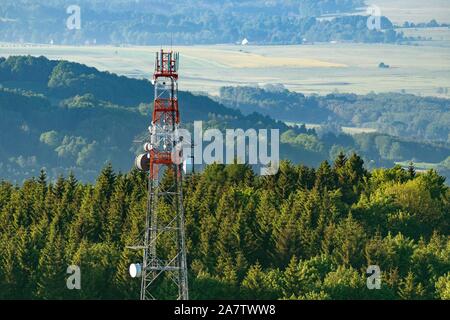 Ein Telecommunication Tower auf der Spitze eines bewaldeten Hügel auf einer Luftaufnahme. Stockfoto