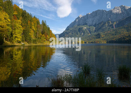 Standup paddleboarding auf Eibsee und Zugspitze im Herbst, Bayern, Deutschland Stockfoto