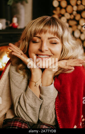 Close up Portrait von schönen jungen Mädchen mit langen Locken auf einem Weihnachten Hintergrund mit Beleuchtung. Magic Warm neues Jahr Foto. Gemütliche Einrichtung. Stockfoto