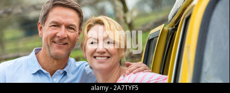 Panoramablick Portraitfotos eines attraktiven, erfolgreichen und glücklichen Mann Frau Paar mittleren Alters zusammen lachen von einem Camper van-Bus. Panorama Web Banner Stockfoto