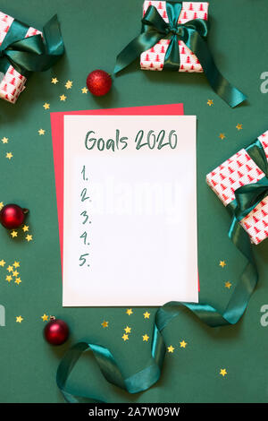 2020 Neue Jahr Ziele, Planung, Checkliste auf Weiß leer, Brief an Santa, Ihre Wunschliste auf grünem Hintergrund. Ansicht von oben. Flach. Vertikale erschossen. Stockfoto