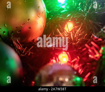 Nasse Weihnachtsverzierungen und Lichter auf einem im Baum Stockfoto