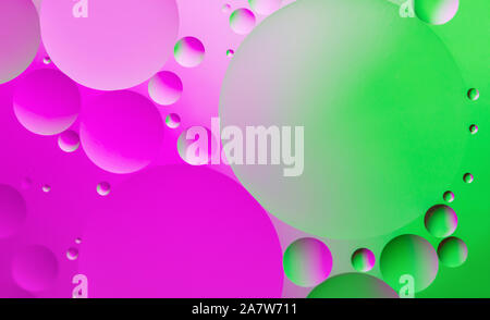 Farbenfrohe abstrakte Hintergrund. Rosa, grüne Kreise und Öl keine Luftblasen im Wasser Nahaufnahme. Makro Abstraktion. Rainbow öl Textur und Muster. Stockfoto