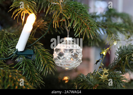 Weihnachtsschmuck hängen von einem Weihnachtsbaum. Schöne weiße Kugel Ornamente und Kerzen für Weihnachten Thema Dekorationen gedacht. Stockfoto