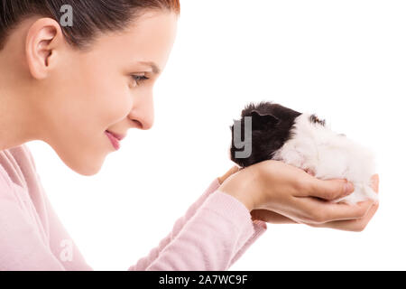 Das Porträt einer jungen schönen Frau an ihrem Haustier Meerschweinchen suchen und lächelnd, auf weißem Hintergrund. Stockfoto