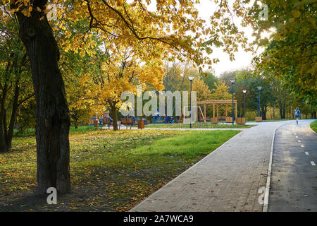 Moskau, Russland - Oktober 03, 2019: Herbst Blick auf Fußgängerweg im Park in der Nähe von Zapovednaya Straße. Kinder und Eltern am neuen Spielplatz Stockfoto