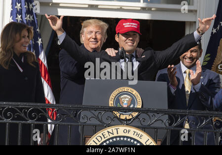 Washington, United States. 04 Nov, 2019. Präsident Donald Trump Lächeln, da Washington Nationals Spieler Kurt Suzuki ein 'Make Amerika wieder einmal Super" hat im Rahmen einer Zeremonie für die World Series Champions auf der Truman Balkon im Weißen Haus am Montag trägt, 4. November 2019. Links ist die erste Dame Melania Trump, rechts Staatsangehörigen manager Dave Martinez applaudiert. Foto von Pat Benic/UPI. Quelle: UPI/Alamy leben Nachrichten Stockfoto