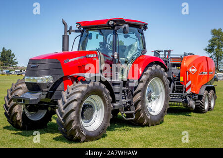 Amberley, Canterbury, Neuseeland, 2. November 2019: Ein brandneuer Fall Red farm Traktor mit einem roten Heu pressen auf der Anzeige befestigt, die an der A&P Showgrounds Stockfoto