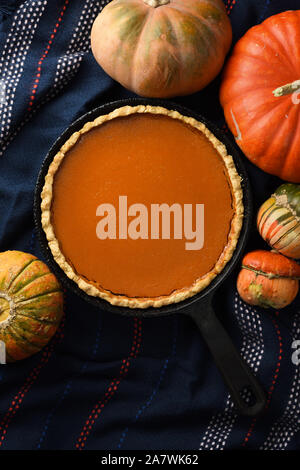 Hygge noch leben Flach. Hausgemachte Pumpkin Pie mit winterkürbisse auf Wolle Tuch auf schwarzem Hintergrund Kopie Raum Stockfoto