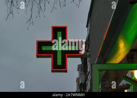 Apotheke Green Cross beleuchtet mit Neon und LED-Leuchten in den Sonnenuntergang. Stockfoto