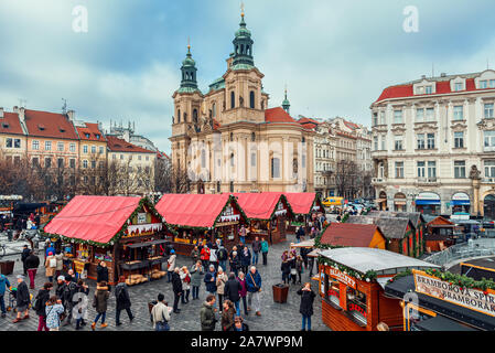 Menschen zu Fuß unter Holz- Kiosk mit Souvenirs und traditionelles Essen während der Weihnachtsmarkt in Prag. Stockfoto
