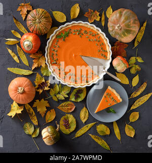 Flach von Pumpkin Pie mit organischen Kürbisse und Herbstlaub auf schwarzem Hintergrund. Thanksgiving Konzept, Ansicht von oben Stockfoto