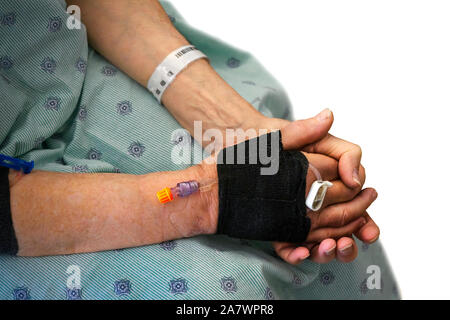 Nahaufnahme der Hand eines männlichen Patienten mit eine intravenöse Spritze, sitzen auf einem Krankenbett, und wartet auf die Krankenschwester. Auf weissem Hintergrund. Stockfoto