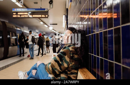Paar sitzen in der U-Bahn Station für einen Zug zusammen warten Stockfoto