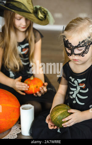 Zwei Schwestern gekleidet im Skelett Kostüme für Halloween mit Kürbissen Stockfoto