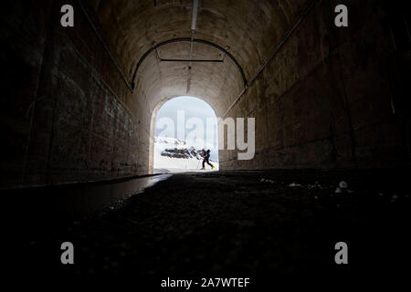 Ein Mann vorbei an einem Tunnel in Island. Stockfoto