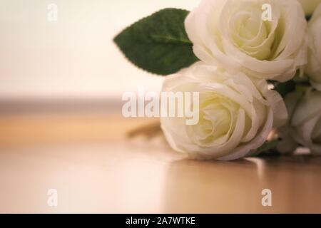 Blumenstrauß aus rosa Blumen in künstlichen weißen Farbe auf Holzboden Stockfoto