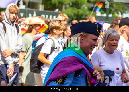 Eine schwedische Polizei Frau mit Regenbogen Flagge um ihre Schultern lacht mit Glück als sie in die jährliche Gay Pride Parade in Malmö beteiligt Stockfoto