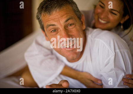 Porträt eines erwachsenen Mann umarmte seine Frau auf einem Bett. Stockfoto