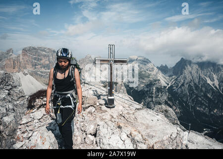 Eine Person mit Kletterausrüstung vor dem Toblinger Knoten Berggipfel in den Dolomiten, Italien Stockfoto