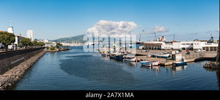 Panorama der Boote im Hafen mit einer großen Wolke über vulkanischen Hügel der Insel in der Ferne sitzen auf einem hellen, sonnigen Tag. Stockfoto