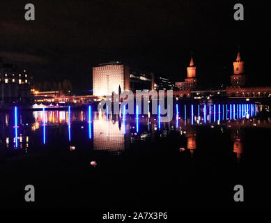 Berlin, Deutschland. 04 Nov, 2019. Neon-blau beleuchteten Bojen schwimmen auf der Spree an der Oberbaumbrücke (r). Der Künstler Rainer Walter Gottemeier symbolisiert die ehemalige Grenze zwischen Ost- und Westberlin bei etwa 150 Meter. Quelle: Annette Riedl/dpa/Alamy leben Nachrichten Stockfoto