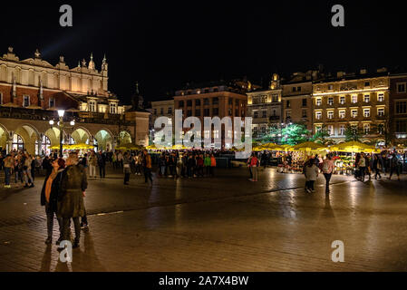 Touristen auf Rynek Glowny, dem Hauptplatz der Altstadt von Krakau bei Nacht Stockfoto