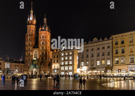 Die Marienkirche in Krakau in den Rynek Glowny Hauptplatz in der Altstadt bei Nacht mit Touristen Stockfoto