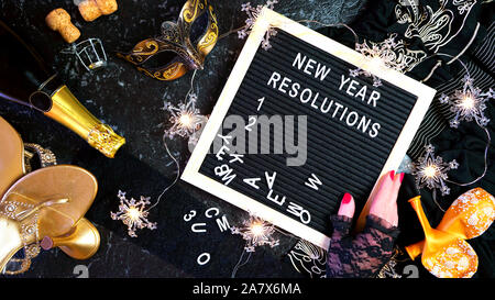 Silvester Entschließungen flatlay mit Brief und Schwarz und Gold party Dekorationen. Stockfoto