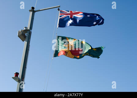 Die australische Nationalflagge und die Boxing-Kangaroo-Flagge wehen im Wind vor einem blauen Himmel, Adelaide, South Australia. Stockfoto