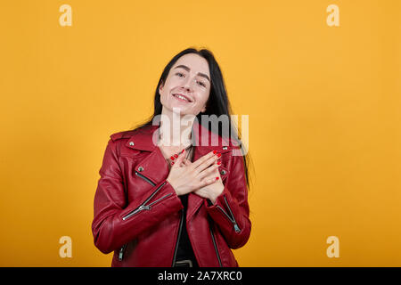 Portrait von lächelnden angenehme junge Frau, Hände auf die Brust, Herz Stockfoto