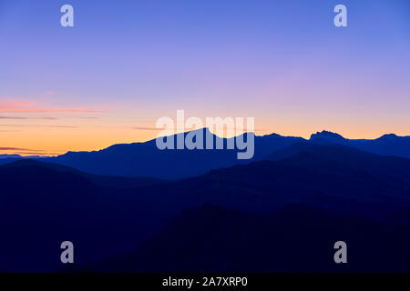 Silhouetten der Berge gegen den Himmel. Panorama der Berge vor dem Hintergrund von Sunrise. Stockfoto