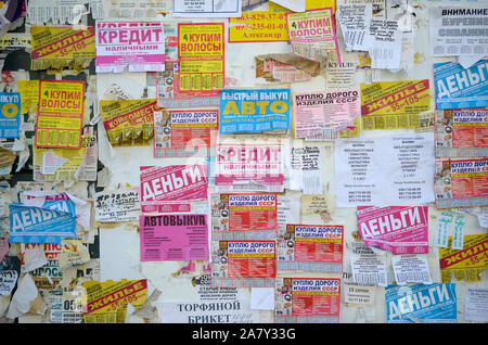 KHARKOV, UKRAINE - OKTOBER 2, 2019: Grunge Message Board mit vielen Werbung. Menschen Verbreitung von Werbung und Informationen auf weißem Papier als pos Stockfoto