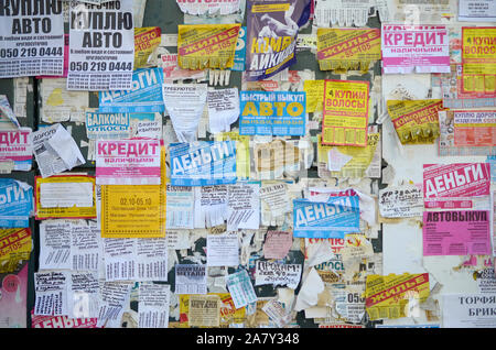 KHARKOV, UKRAINE - OKTOBER 2, 2019: Grunge Message Board mit vielen Werbung. Menschen Verbreitung von Werbung und Informationen auf weißem Papier als pos Stockfoto