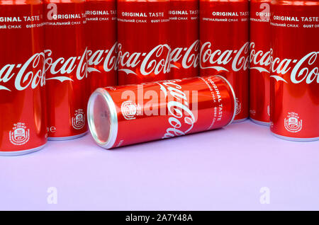 KHARKOV, UKRAINE - OKTOBER 2, 2019: Coca-Cola Logo auf Aluminiumdosen und auf Licht lila Hintergrund platziert. Die meisten berühmten Soda drink Produkt comp Stockfoto