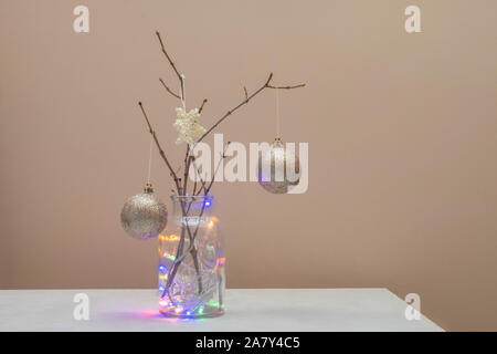 Alternative Christmas Tree Konzept. Weihnachtsbaum aus Branchen und mit Häkeln Schneeflocke und goldenen Kugeln auf neutralem Hintergrund eingerichtet Stockfoto
