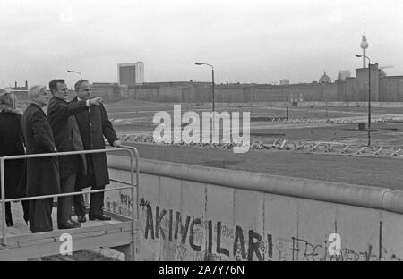 Vice President George Bush sieht über die Berliner Mauer in Ost-berlin während seiner Tour durch die Stadt. Er ist der regierende Bürgermeister von weizacker und Bundeskanzler Kohl begleitet. Stockfoto