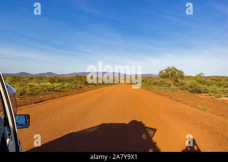 Rote australische Ländliche Straße mit Bewölkt blauer Himmel, Western Australia Stockfoto