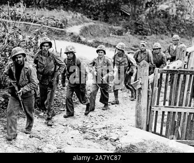 Kolumnist Ernie Pyle (3. von links) Märsche zusammen mit der ersten Abteilung Marines auf Patrouille in Okinawa Stockfoto