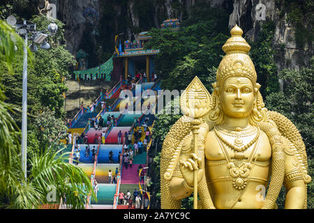 (Selektive Fokus) einen atemberaubenden Blick auf den Lord Murugan Statue im Vordergrund und Touristen klettern eine bunte Treppe, die zu den Batu Höhlen Stockfoto